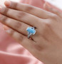 turquoise blue topaz and zircon ring in rhodium over sterling silver worn on a hand