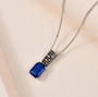 blue spinel brown zircon and white zircon pendant necklace in black and white rhodium over sterling silver shown in a lifestyle photo
