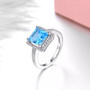 close up of square cut swiss blue topaz halo ring in rhodium over sterling silver