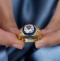 petalite and blue sapphire gents ring in 18k yellow gold over sterling silver worn on a hand