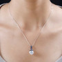 moissanite and blue sapphire pendant necklace in rhodium over sterling silver worn around the neck