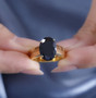 oval black jade solitaire ring in 18k yellow gold over sterling silver worn on a hand
