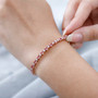 pink tourmaline and moissanite tennis bracelet in 18k rose gold over sterling silver worn on a wrist