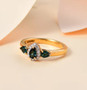 indicolite tourmaline and moissanite three stone ring in 18k yellow gold over sterling silver shown in a lifestyle photo