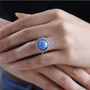 ceruleite tanzanite and zircon halo ring in rhodium over sterling silver worn on a hand