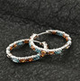 blue and orange zircon hoop earrings in rhodium over sterling shown in a lifestyle photo