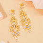 cubic zirconia articulating chandelier earrings in 18k yellow gold over sterling silver shown in a lifestyle photo
