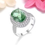 oval green fluorite and white zircon halo ring in rhodium over sterling silver shown in a lifestyle photo