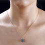 aquamarine champagne and white diamond round double halo solid 14k yellow gold pendant necklace worn around the neck