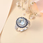 aquamarine blue sapphire and zircon double halo ring in rhodium over sterling silver shown in a lifestyle photo