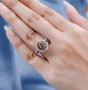 oval champagne and white diamond halo ring in 14k rose gold worn on a hand