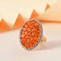 fire opal and white zircon cluster halo ring in 18k yellow gold over sterling silver shown in a lifestyle photo