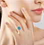blue apatite blue and white diamond double halo ring in solid 10k white gold worn on a hand