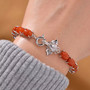 elephant and red jade tennis bracelet in rhodium over sterling silver worn on a wrist