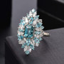 blue zircon blue apatite and white zircon cluster ring in rhodium over sterling silver shown in a lifestyle photo