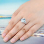 sky blue topaz three stone and white zircon accent ring in rhodium over sterling silver worn on a hand