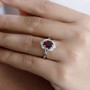 garnet and white zircon split shank ring in rhodium over sterling silver worn on a hand
