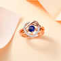 blue kyanite and moissanite heart love knot two ring set in 18k rose gold over sterling silver shown in a lifestyle photo