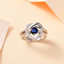 blue kyanite and moissanite heart love knot two ring set in rhodium over sterling silver shown in a lifestyle photo