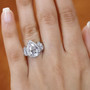 pear moissanite trilogy halo ring in rhodium over sterling silver worn on a hand