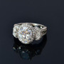 close up of oval moissanite trilogy halo ring in rhodium over sterling silver