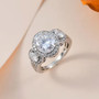oval moissanite trilogy halo ring in rhodium over sterling silver shown in a lifestyle photo