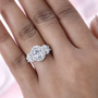 oval moissanite trilogy halo ring in rhodium over sterling silver worn on a hand