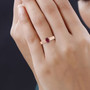oval rubellite tourmaline solitaire ring in 14k rose gold worn on a hand