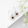 full view of dancing garnet and white zircon double halo dangle earrings in rhodium over sterling silver