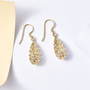 floral drop shepherds hook earrings in solid 10k yellow gold shown in a lifestyle photo