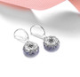 close up of tanzanite and white zircon dangle earrings in rhodium over sterling silver