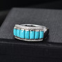 turquoise seven stone band ring with moissanite accents in rhodium over sterling silver shown in a lifestyle photo