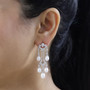 freshwater pearl and moissanite chandelier earrings in rhodium over sterling silver worn on the ear