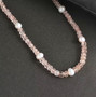 rose quartz rondelle beads and freshwater pearl necklace with rhodium over sterling silver clasp shown in a lifestyle photo