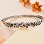 bezel set multi color tourmaline and white zircon bangle bracelet in 18k yellow gold over sterling silver shown in a lifestyle photo