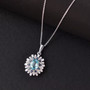 blue zircon blue sapphire and moissanite pendant necklace in rhodium over sterling silver shown in a lifestyle photo