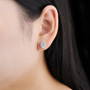 oval ethiopian opal and white zircon stud earrings in rhodium over sterling silver worn on the ear