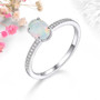 oval ethiopian opal and white zircon halo ring in rhodium over sterling silver shown in a lifestyle photo