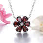 garnet and white zircon flower cluster necklace in rhodium over sterling silver shown in a lifestyle photo