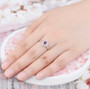 ruby and white zircon halo ring in rhodium over sterling silver worn on a hand