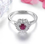 front view of ruby and white zircon halo ring in rhodium over sterling silver