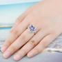 tanzanite and white zircon flower ring in rhodium over sterling silver worn on a hand