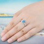 swiss blue topaz and white zircon solitaire ring in rhodium over sterling silver worn on a hand