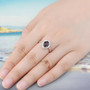 garnet and white zircon halo ring in rhodium over sterling silver worn on a hand