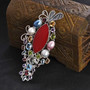 artisan crafted red coral and multi gemstone pendant brooch in rhodium over sterling silver shown in a lifestyle photo