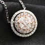 pink and white diamond round cluster necklace in solid 14k rose and white gold shown in a lifestyle photo