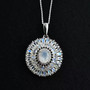 close up of rainbow moonstone and moissanite pendant necklace in rhodium over sterling silver