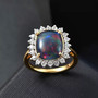 boulder opal triplet and white zircon cushion halo ring in 18k yellow gold over sterling silver shown in a lifestyle photo