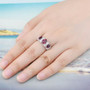 rhodolite garnet and white zircon three stone ring in rhodium over sterling silver worn on a hand