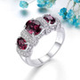 rhodolite garnet and white zircon three stone ring in rhodium over sterling silver shown in a lifestyle photo